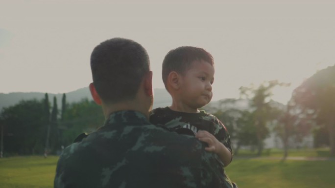 士兵父亲在公园里抱着儿子玩