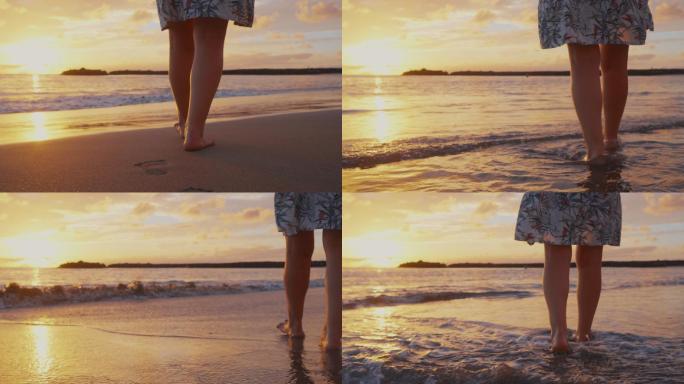 女人光着脚沿着沙滩走向海浪和美丽的日落