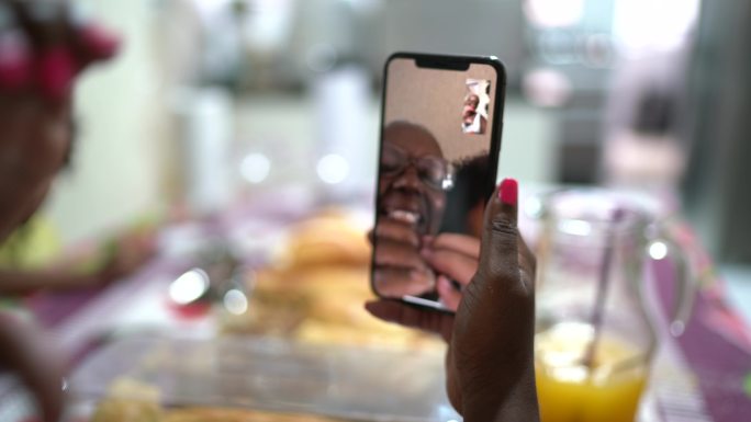 在家吃早餐时用手机视频聊天的女人