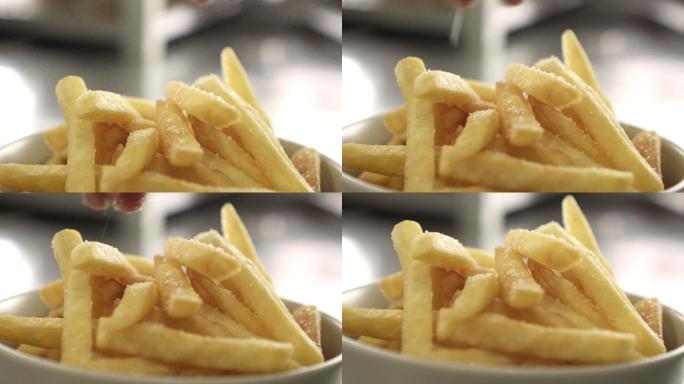 在炸薯条上撒盐特写镜头垃圾食品制作零食