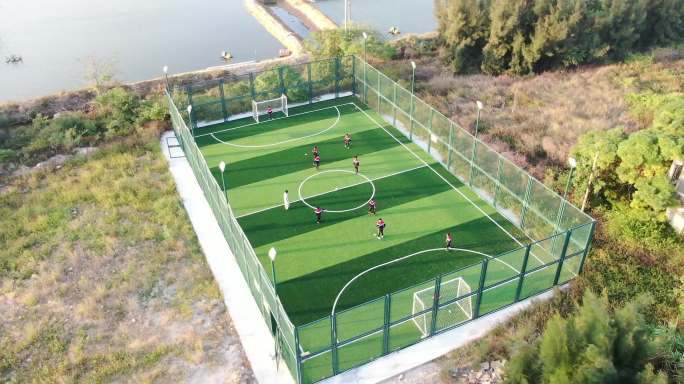 海边乡村小学生在新建的足球场踢足球实拍