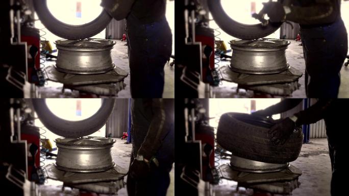从事脏活的技工磨损轮辋上的安装轮胎