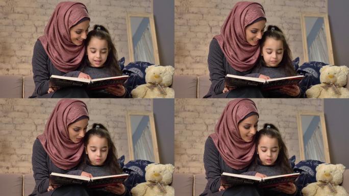 母亲教女儿阅读。阿拉伯女子戴头巾女子妇女