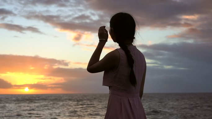 女孩独自海边吹风看夕阳