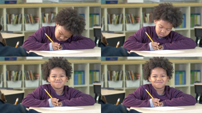 小孩子写作业时抬起头，微笑的看着镜头