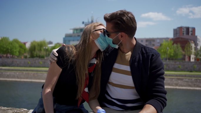 一对可爱的年轻夫妇戴着防护面罩接吻