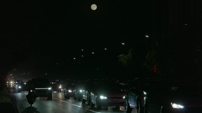 城市夜晚车流月亮慢慢升起