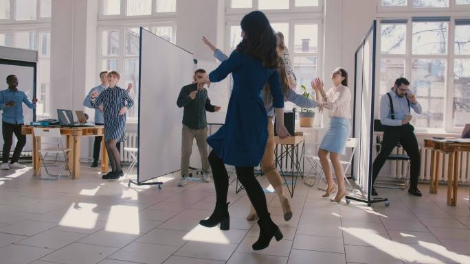 女同事与多民族公司员工一起跳舞庆祝