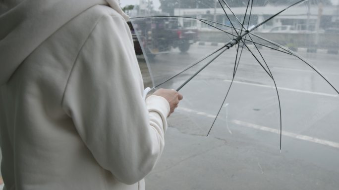 在等待出租车时打开雨伞