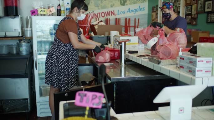 餐厅工作人员戴着口罩和手套组装送货单