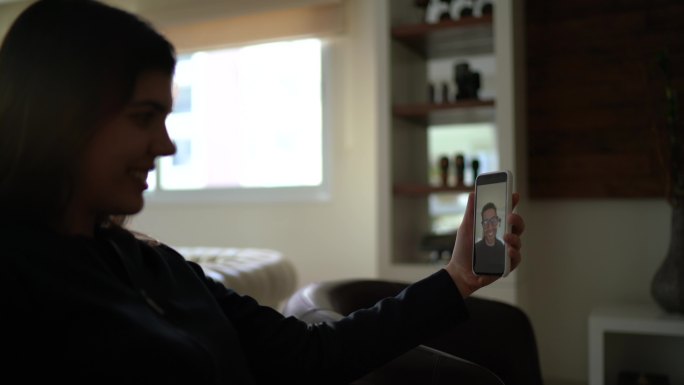 年轻女子用智能手机打视频电话给她的男朋友