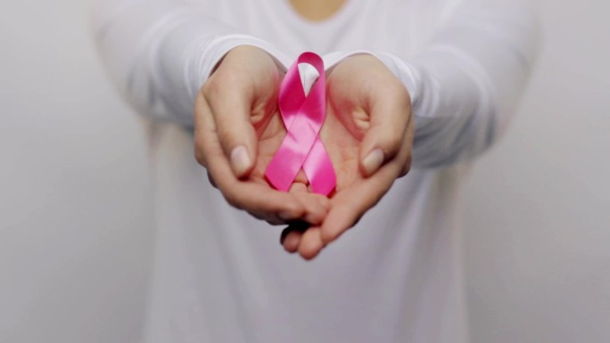 手持粉色癌症意识丝带的妇女