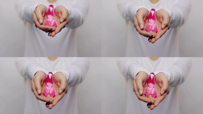 手持粉色癌症意识丝带的妇女