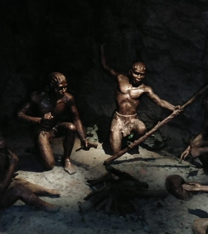 原始人祖先在山洞里烤火的雕像