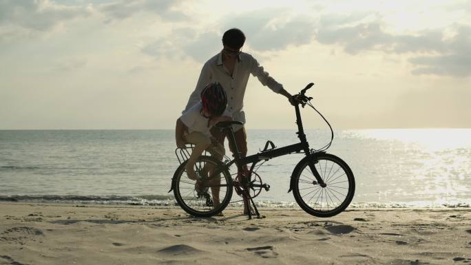 爸爸和儿子在海滩上骑自行车