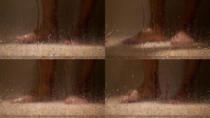 在玻璃门后淋浴的人的腿