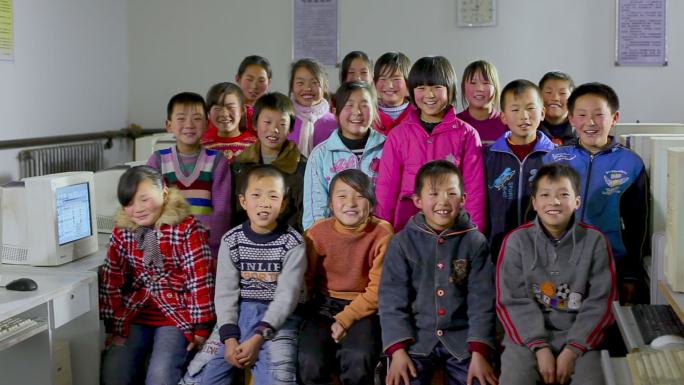 贫困地区的小学生在电脑教室合影微笑