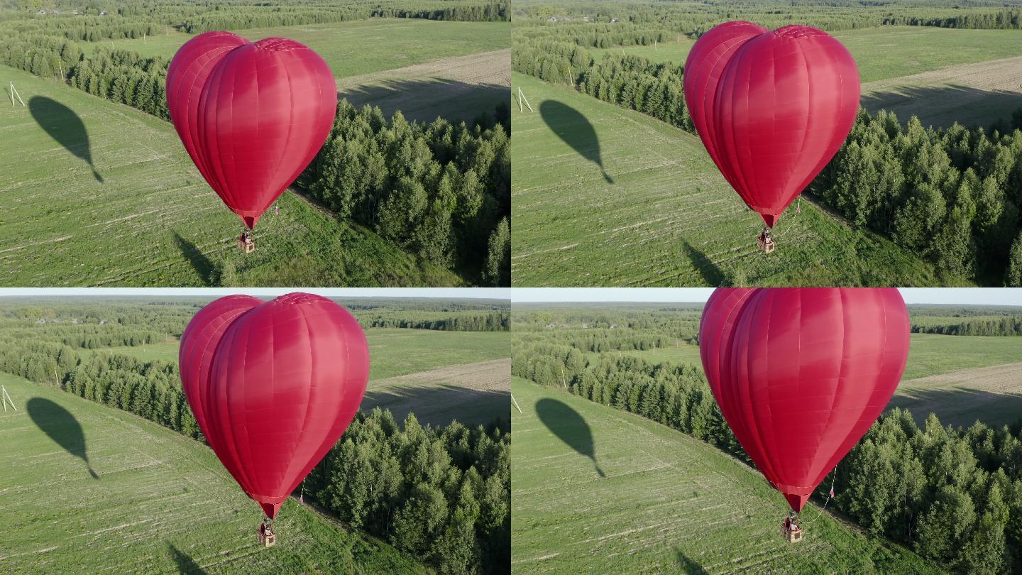 红色的爱心气球在田野上飞翔