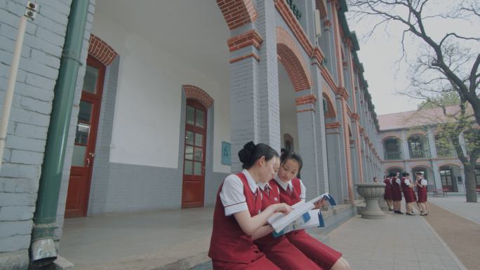 穿校服的女学生在校园里读书交谈
