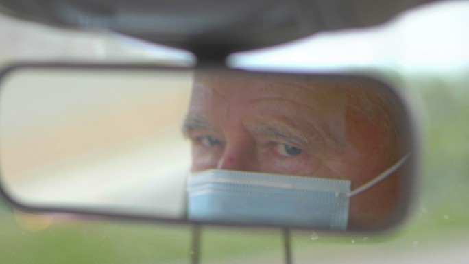 老年人在流感流行期间戴着口罩开车