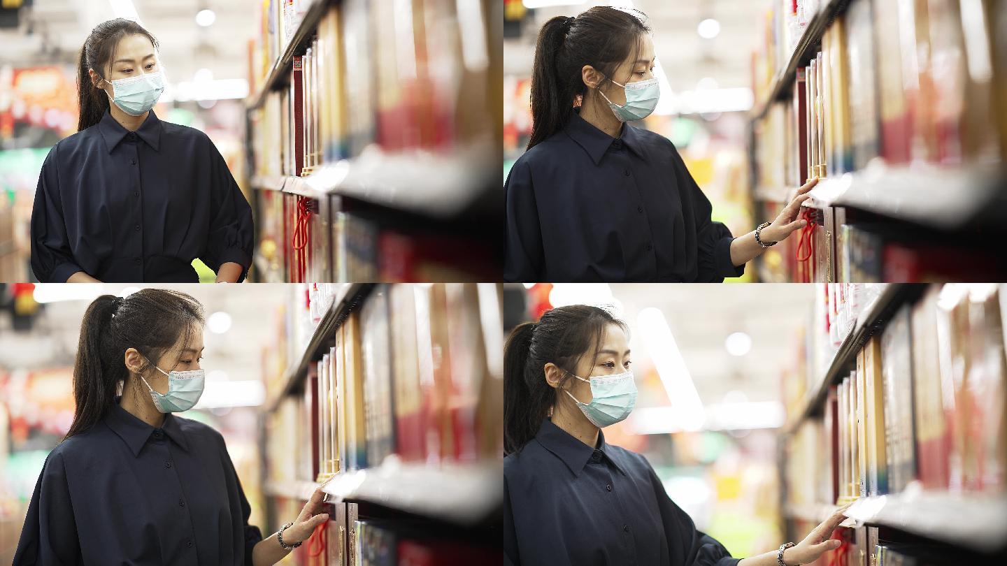 年轻中国女性戴着口罩在超市购物