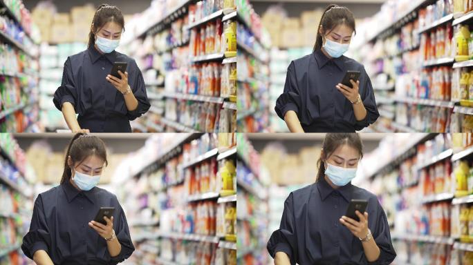 年轻中国女性拿着手机逛超市
