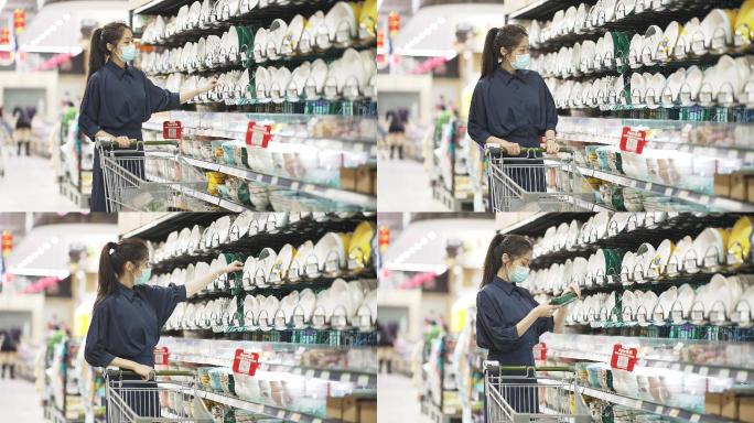 年轻女性戴口罩推着购物车逛超市