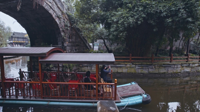 古镇石拱桥和河水里的观光游览船