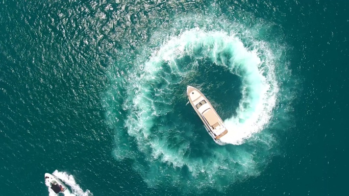 游艇在形成波浪的圆圈中行驶