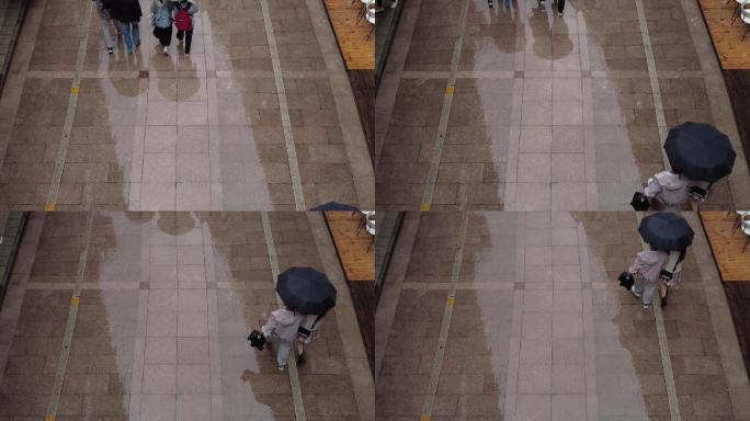下雨天撑伞的行人地上的雨滴