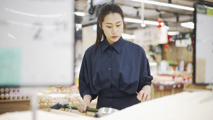 年轻中国女性在超市购买大米