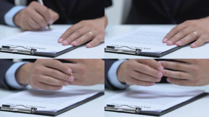 男人签署离婚证书，从手指上取下订婚戒指