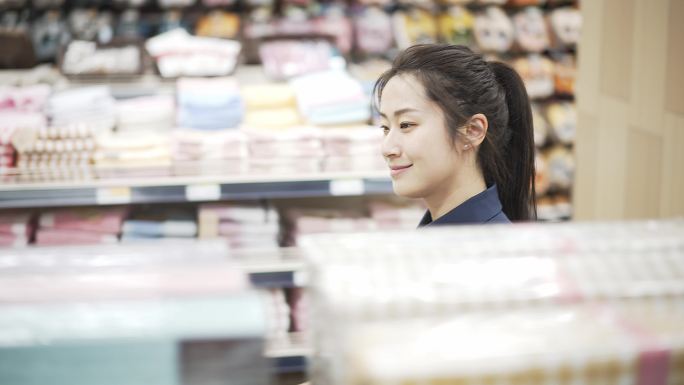 年轻中国女性在超市选购毛巾