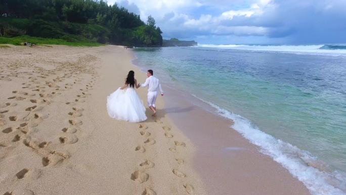 海边沙滩情侣恋人穿着婚纱牵手奔跑