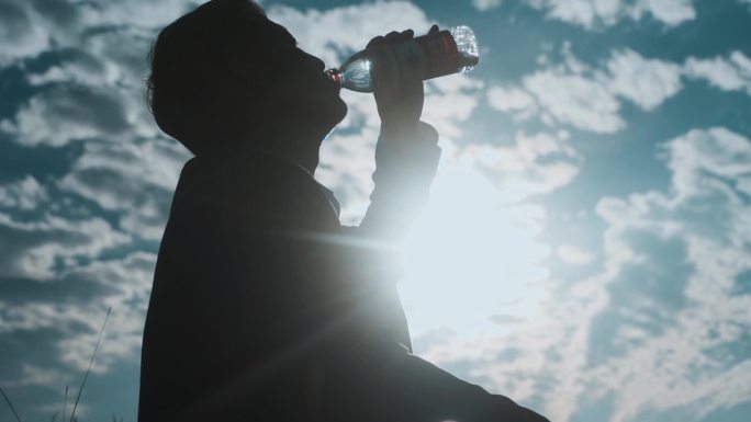 成功人士登山人物逆光剪影口渴喝水阳光洒下