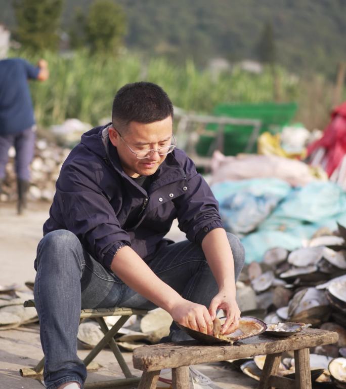 诸暨珍珠养殖场中年中国男性在开蚌