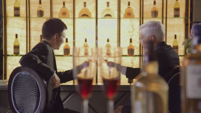 外籍商务人士和中方职员在酒吧喝酒交谈