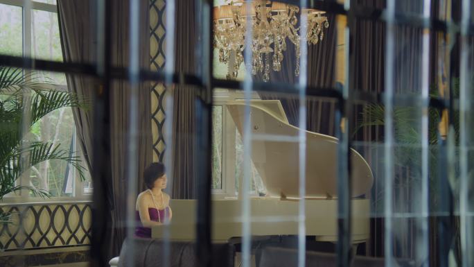 穿礼服裙子的女士在别墅里弹钢琴