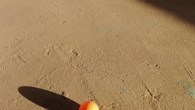 水泥地面滚动的乒乓球