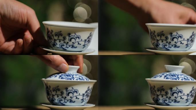 把茶杯放到桌子上盖上茶杯盖手部动作特写