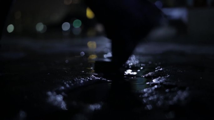夜晚灯光行人皮鞋踩水倒影水洼街道下雨天