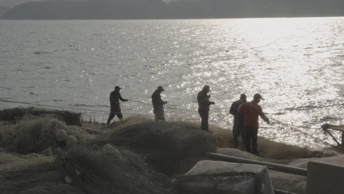 夕阳下的渔民收网