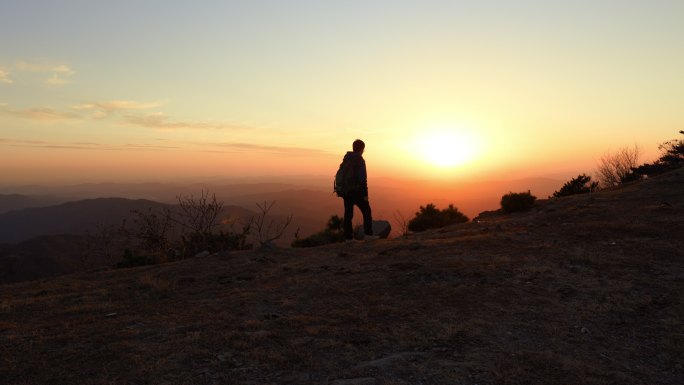 4K年轻男性背包在山顶上看日出举手
