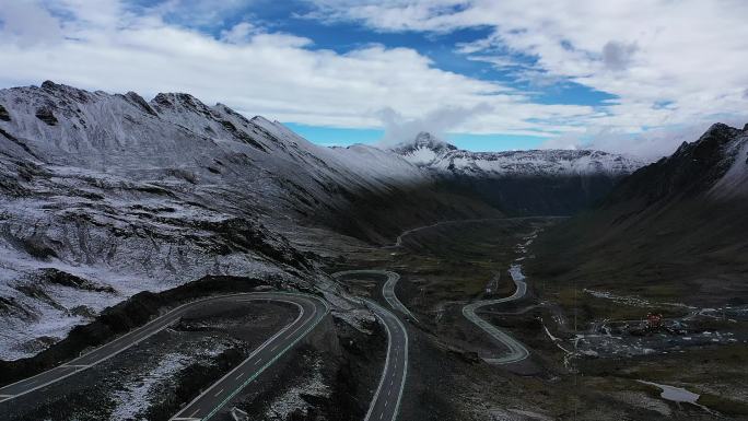 航拍雪山公路汽车行驶