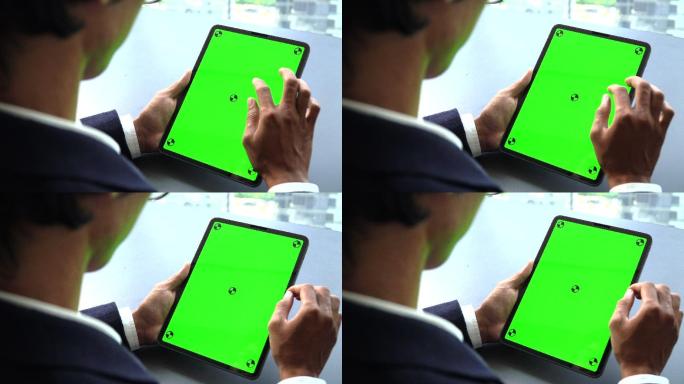 商人看着平板电脑的绿色屏幕