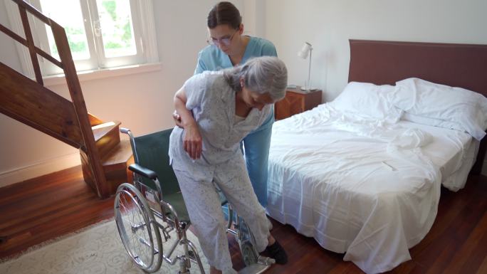 医护人员帮助老年妇女坐在轮椅上