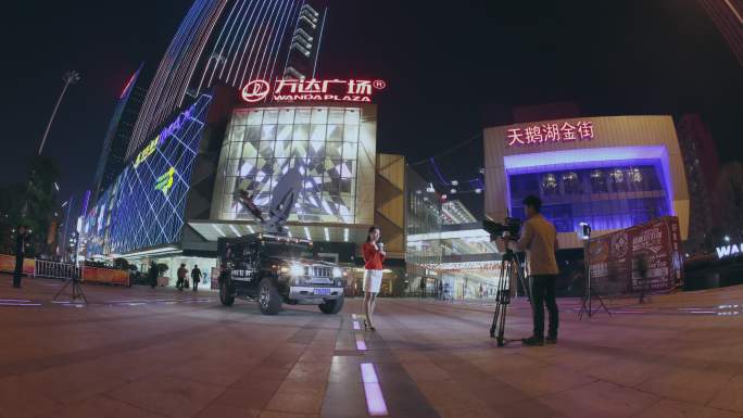 电视新闻记者夜晚在商业街做直播报道