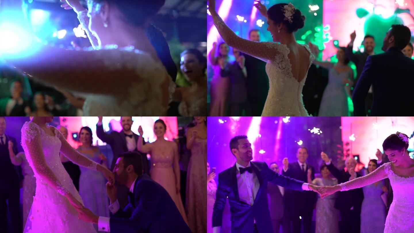 新婚夫妇翩翩起舞，而婚礼宾客则手舞足蹈