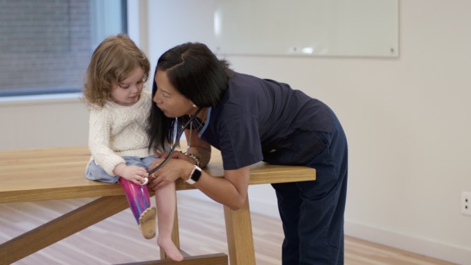 小女孩带着假腿小孩脚部检查听诊器家庭护理