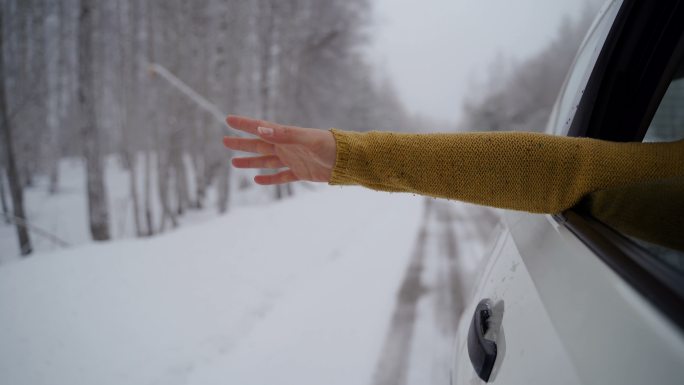冬天伸出窗外的女生的手